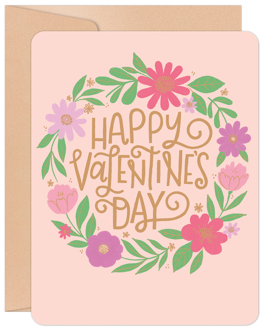 Happy Valentine's Day floral wreath greeting card with pink, purple, and green flowers on a light pink background, includes an envelope.