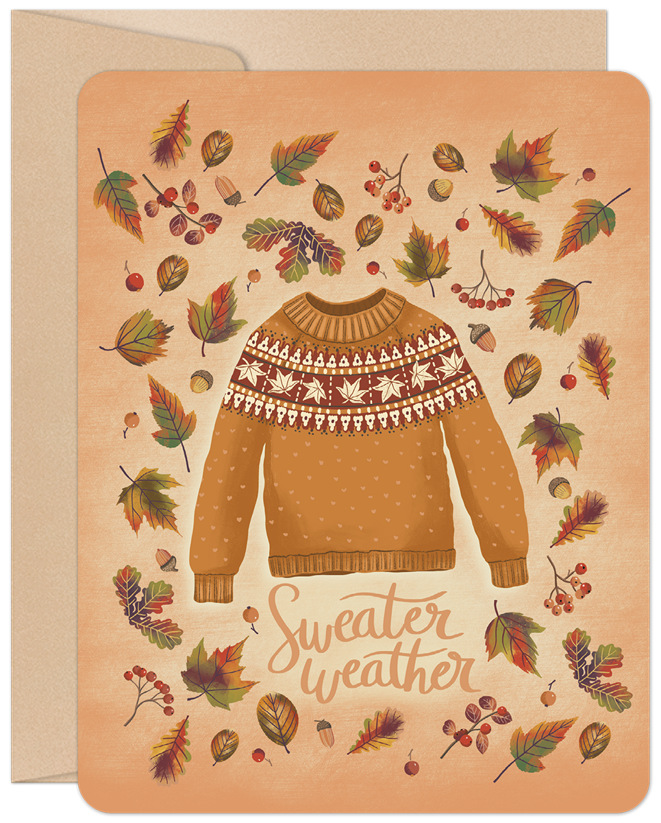 Front of a cozy fall greeting card with an orange sweater, fair isle pattern, surrounded by colorful autumn leaves, acorns, and berries. Text says 'Sweater weather'.