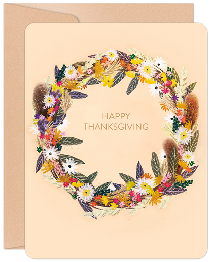 Front of a Happy Thanksgiving greeting card featuring a vibrant, artistic harvest wreath with colorful autumn flowers and foliage.