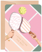 Greeting card featuring two hands holding pickleball paddles with floral and striped designs, a pickleball, and the pun text 'I DINK YOU'RE THE BEST' on a pastel geometric background. Includes a kraft envelope.