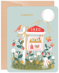 Charming 'Congrats' new home greeting card featuring a 'SOLD' sign, a quaint house illustration, strawberries, a bunny, bird, and a festive balloon on a light blue background.