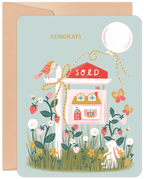 Charming 'Congrats' new home greeting card featuring a 'SOLD' sign, a quaint house illustration, strawberries, a bunny, bird, and a festive balloon on a light blue background.