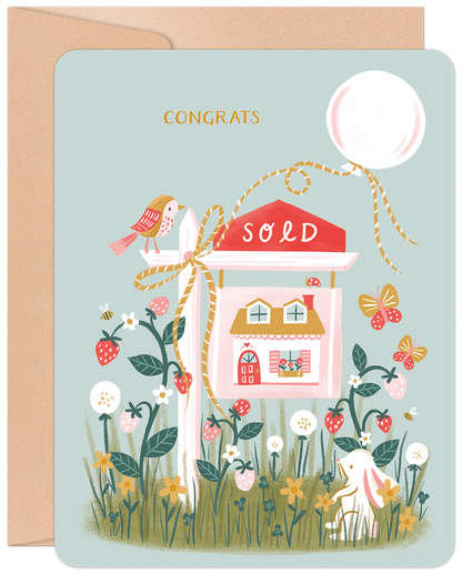 Whimsical new home card with 'CONGRATS', a 'SOLD' sign, a house, rabbit, bird, strawberries, and flowers on a light blue background.