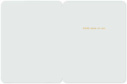 Inside of a new home card with the text 'YOU'RE HOME AT LAST.' in orange on a simple light blue background.