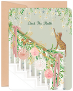 Cute cat decorating a festive green and pink garland on a white staircase, with 'Deck The Halls' text. Ideal holiday greeting card for friends and family.