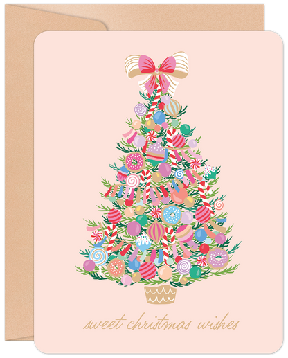Sweet Christmas Wishes greeting card with a whimsical candy-decorated Christmas tree on a soft pink background and kraft envelope.