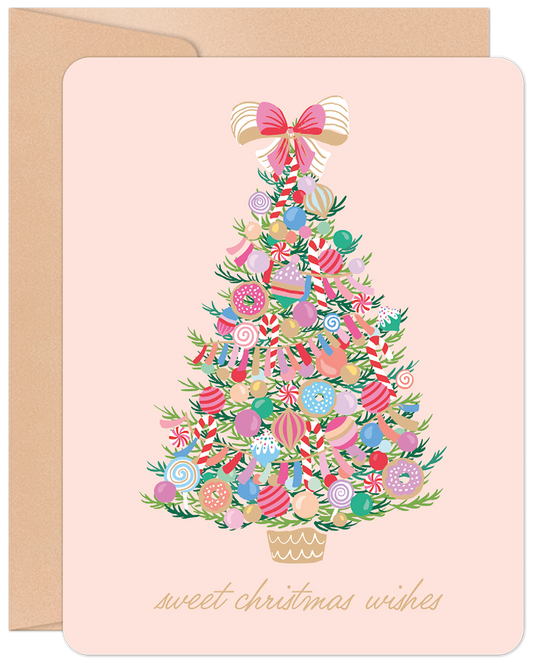 Sweet Christmas Wishes greeting card with a whimsical candy-decorated Christmas tree on a soft pink background and kraft envelope.