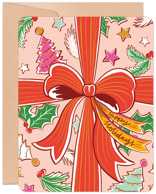 Front of a festive pink Christmas card with a large red bow, 'Happy Holidays' tag, evergreen branches, stars, and colorful Christmas trees.