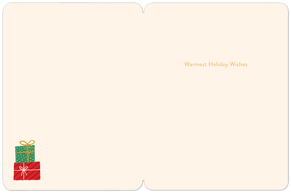Inside of a cream-colored Christmas card featuring 'Warmest Holiday Wishes' in gold text and a stack of festive gift boxes.