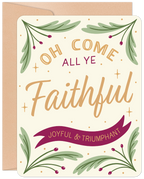 Front of a religious holiday greeting card featuring the text 'Oh Come All Ye Faithful' in gold and cream, surrounded by festive green branches with red berries on a light cream background, accompanied by a kraft paper envelope.
