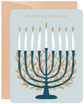 Elegant Hanukkah greeting card front featuring a teal and gold leaf menorah with nine lit candles, 'HAPPY HANUKKAH' text, and a matching envelope on a light blue background.