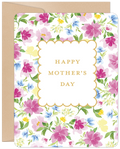 Front view of an elegant Mother's Day greeting card. It features a vibrant watercolor floral pattern with pink, blue, and yellow blossoms and green leaves on a white background. A gold-edged scalloped frame in the center reads "HAPPY MOTHER'S DAY" in classic gold text. A brown kraft envelope is partially visible behind the card.