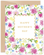 Front view of an elegant Mother's Day greeting card. It features a vibrant watercolor floral pattern with pink, blue, and yellow blossoms and green leaves on a white background. A gold-edged scalloped frame in the center reads "HAPPY MOTHER'S DAY" in classic gold text. A brown kraft envelope is partially visible behind the card.