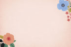Blank interior or back of a light pink greeting card, featuring a decorative blue flower in the top right corner and an orange flower in the bottom left, ready for a custom message.