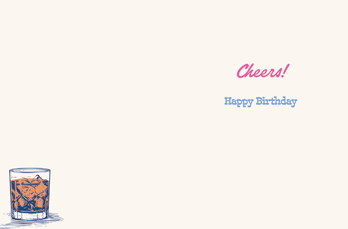 Interior of a lighthearted birthday card showing 'Cheers! Happy Birthday' in vibrant pink and blue text, with a small illustration of a rocks glass in the bottom left corner, offering ample space for a personal message.