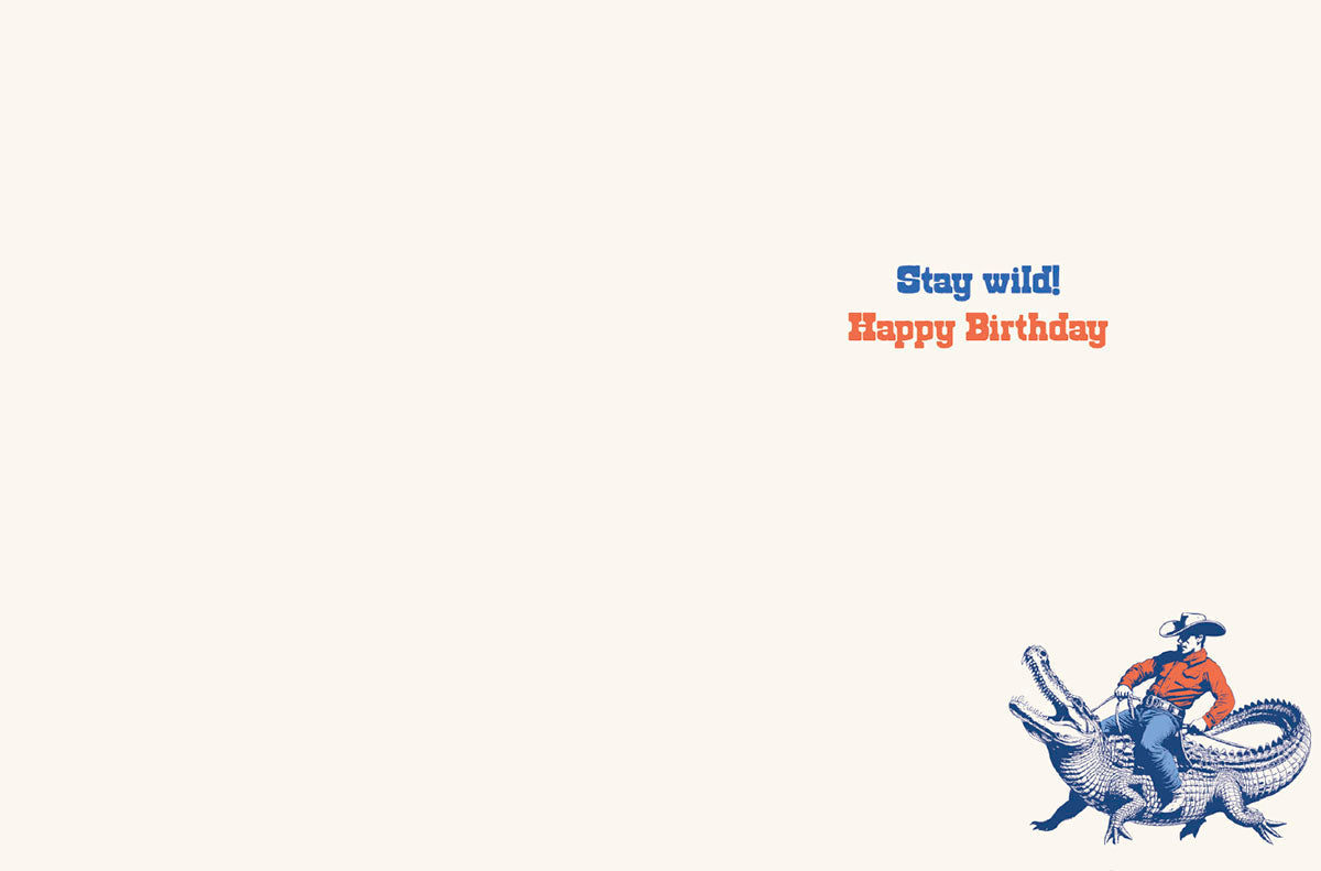 Inside of a humorous Him Birthday greeting card, showing 'Stay wild! Happy Birthday' text and a small cowboy on alligator illustration.
