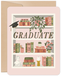 Front of a graduation greeting card featuring a charming bookshelf illustration. The shelves are filled with classic books, potted plants, a classical bust, a candle, and a prominent graduation cap. The word "GRADUATE" is displayed in large, elegant letters in the center.