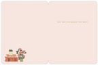 Inside of a graduation greeting card. The pale pink interior displays the message "YOU ARE LITERALLY THE BEST!" in a delicate font, with a small decorative illustration of stacked books and a rose plant in the bottom left corner.