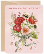 Front of a watercolor Valentine's Day greeting card featuring a lush bouquet of red roses, pink peonies, and white anemones tied with a black and white striped ribbon, set against a soft pink background with falling petals, all contained within a kraft envelope.