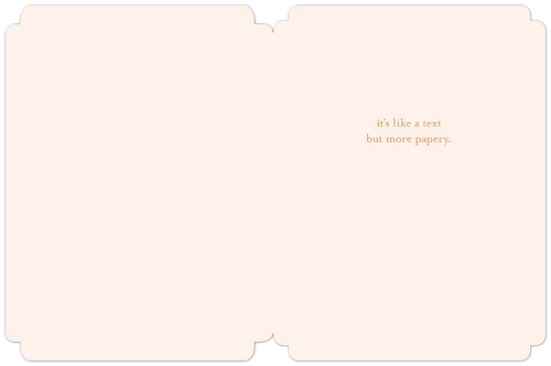 The interior of an open, elegant blush pink greeting card with rounded corners. Subtle text on the right side reads 'it's like a text but more papery.', offering a humorous and lighthearted message.