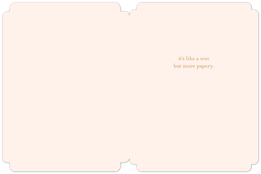 Open light pink greeting card interior revealing lighthearted text 'it's like a text but more papery.', perfect for a friend's special day.