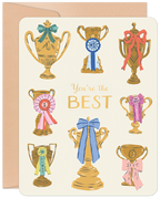 Front of a friendship greeting card with multiple gold trophies adorned with colorful ribbons and bows, proclaiming 'You're the BEST' on a cream background, celebrating a top friend.