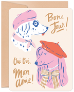 Whimsical greeting card featuring two beret-wearing dogs, a pink poodle and a spotted dalmatian, with 'Bone Jour!' and 'Oui Oui, Mon Amie!' text in gold script, perfect for a special pal.