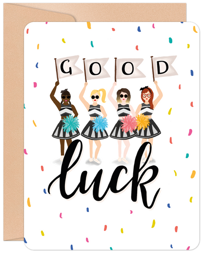 Front of a 'Good Luck' greeting card with diverse cheerleaders holding "GOOD LUCK" banners, surrounded by colorful confetti.