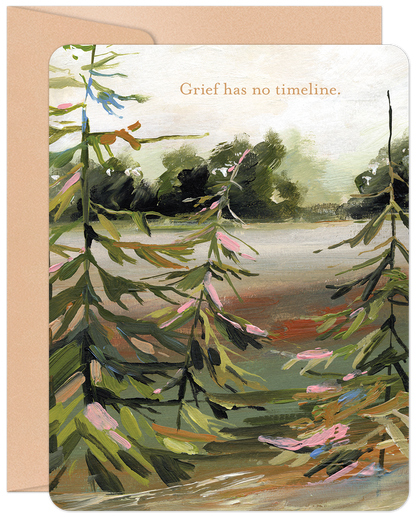 Front of a comforting sympathy card with a peaceful painted landscape of evergreen trees by a lake. Text reads 'Grief has no timeline'.