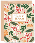 Lighthearted festive greeting card featuring a pattern of red and white candy cane bows, green evergreen sprigs, and orange slices on a cream background, with 'Tis The Season' in a decorative frame.