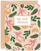 Lighthearted festive greeting card featuring a pattern of red and white candy cane bows, green evergreen sprigs, and orange slices on a cream background, with 'Tis The Season' in a decorative frame.