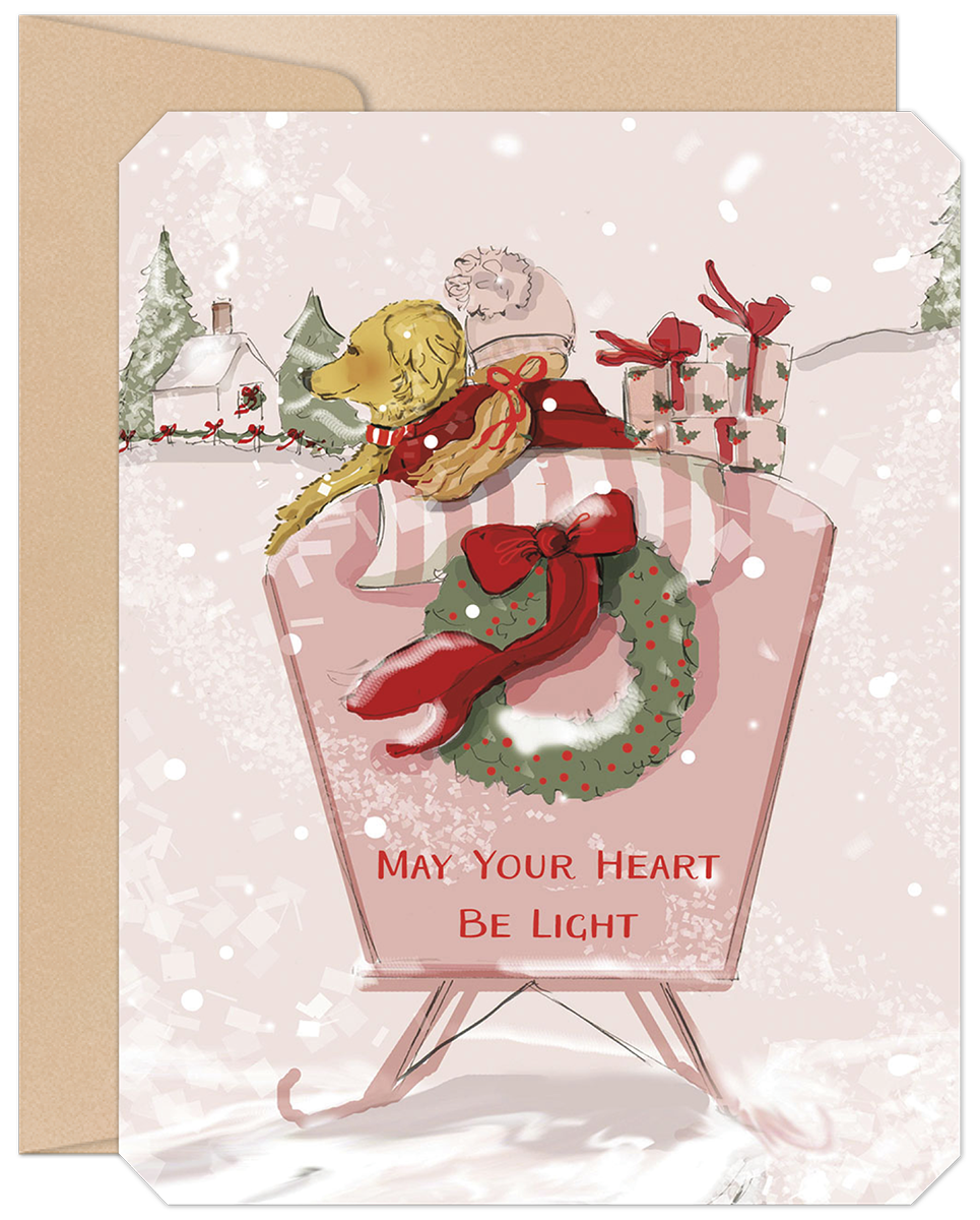 Adorable golden retriever puppy in a winter hat riding a vintage pink sled with festive gifts, a holiday wreath, and falling snow. Front of a heartfelt greeting card featuring a cozy winter village background and the text 'MAY YOUR HEART BE LIGHT'.