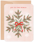 Front of a festive holiday greeting card featuring a watercolor snowflake design made of pine needles, red berries, and pinecones, tied with a red ribbon, on a light pink background with 'JOY TO THE WORLD' text. Includes a brown kraft envelope.