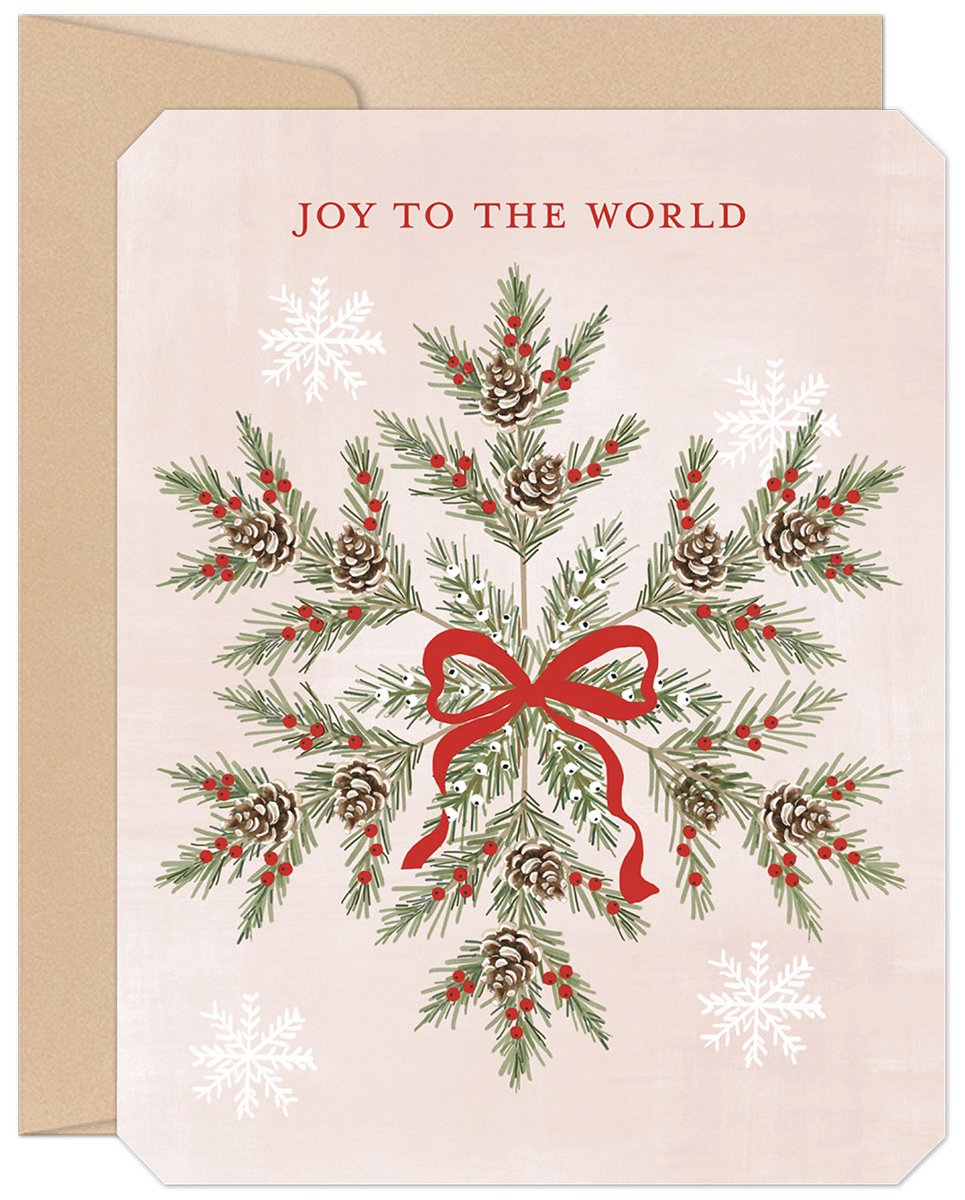 Front of a festive holiday greeting card featuring a watercolor snowflake design made of pine needles, red berries, and pinecones, tied with a red ribbon, on a light pink background with 'JOY TO THE WORLD' text. Includes a brown kraft envelope.