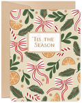 Front of a festive holiday greeting card featuring a pattern of red and white striped bows, candy canes, evergreen branches, and dried orange slices on a beige background. The card reads 'Tis the Season in the center, with a kraft paper envelope peeking from behind. Ideal for sending season's greetings.