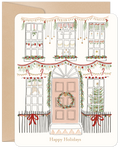 Front of a charming cream-colored holiday card featuring an illustrated house adorned with festive garlands, string lights, ornaments, and red bows, perfect for sending seasonal greetings.
