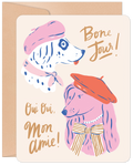 Whimsical greeting card front featuring two charming dogs in berets, one a dalmatian in pink and one a poodle in red, with 'Bone Jour!' and 'Oui Oui, Mon Amie!' text, perfect for dog lovers.