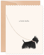 A cream-colored greeting card with scalloped edges, featuring a whimsical illustration of a black Scottish Terrier dog looking up at a dotted line forming an arc, with the text "a little hello" above. The dog wears a pink collar. A kraft envelope peeks out from behind the card.